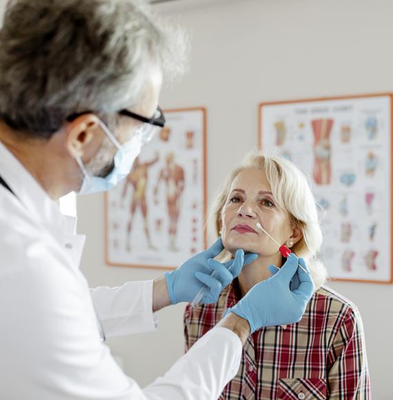 Male doctor performs a nasal swab on a patient