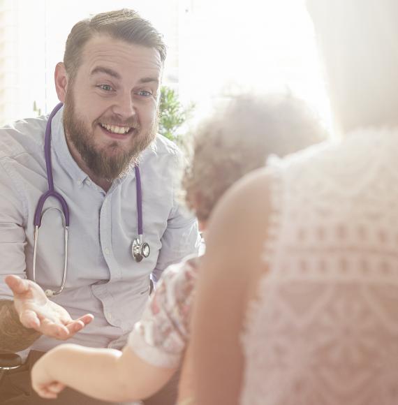 Young male GP talking to a paediatric patient