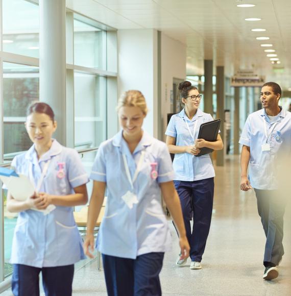 A group of nurses walking through a hospital corridor