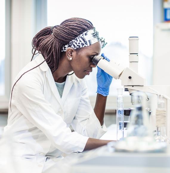 Female scientist looking through a microscope