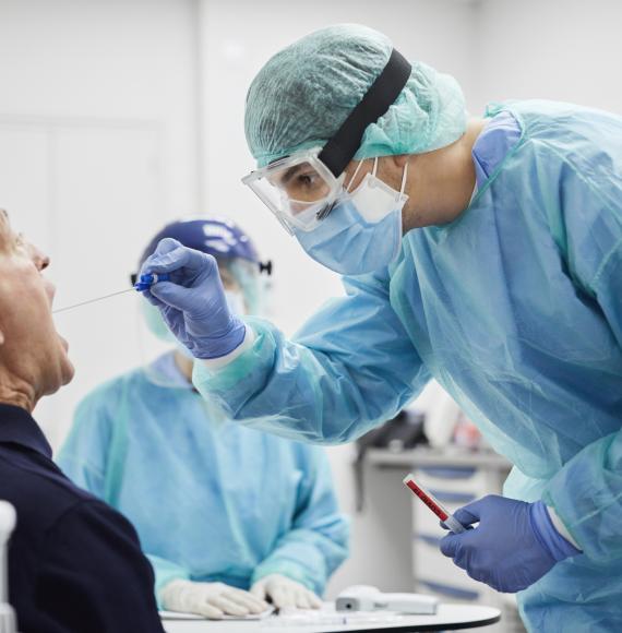 Male patient receiving a throat swab from a medical professional