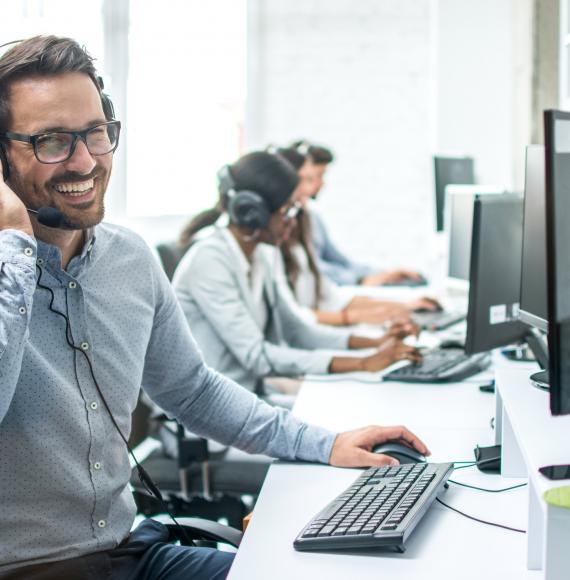 Smiling call centre phone operator, representative of NHS Test and Trace caller