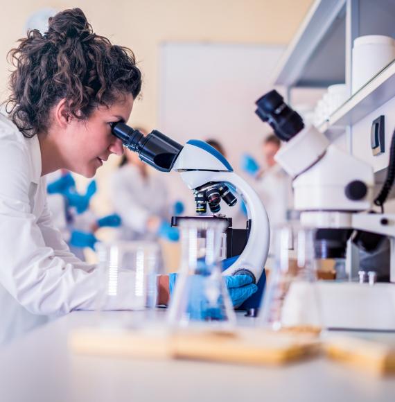 Lab technician operating a microscope