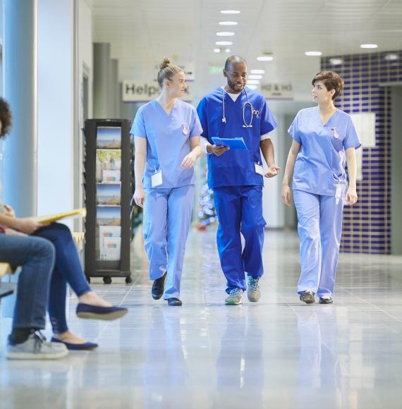 Nurses having a conversation walking through hospital corridors