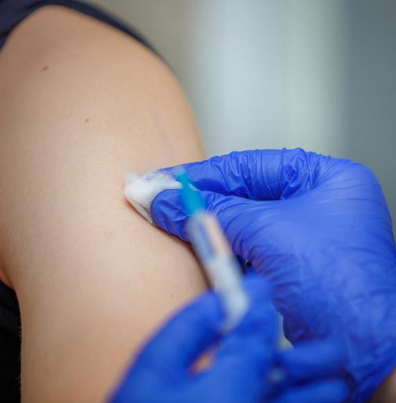 Vaccine dose being administered in a patient's arm