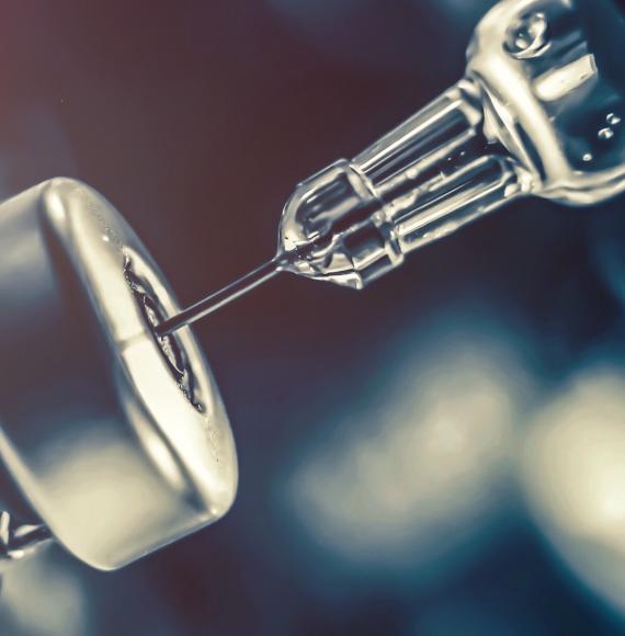 Vaccine bottle being filled with a needle