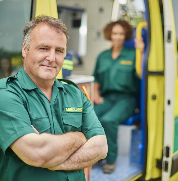 Ambulance driver stands outside his vehicle