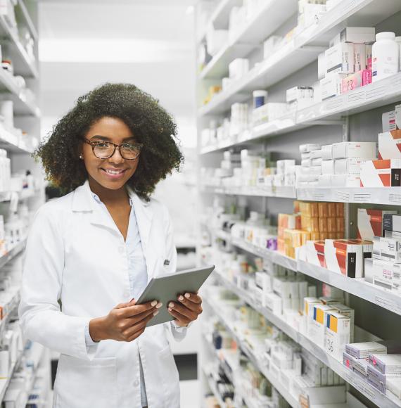 Young female pharmacist standing in an aisle of pharmaceuticals