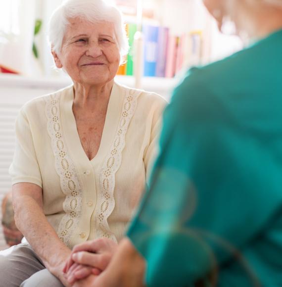 Elderly care home resident in conversation with a nurse