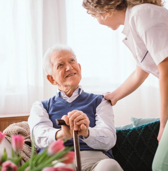 Elderly man being supported by a member of staff