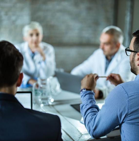 Health meeting discussing around a boardroom table