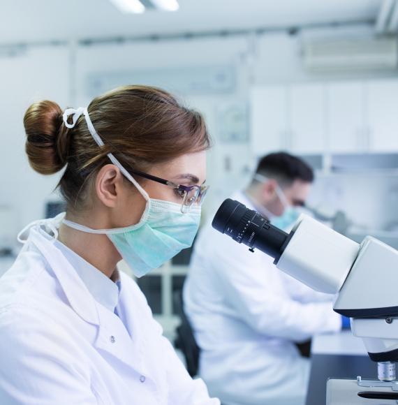 Scientists using a microscope in a lab