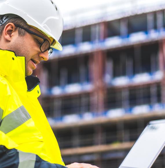 Construction worker looking at plans on a building site