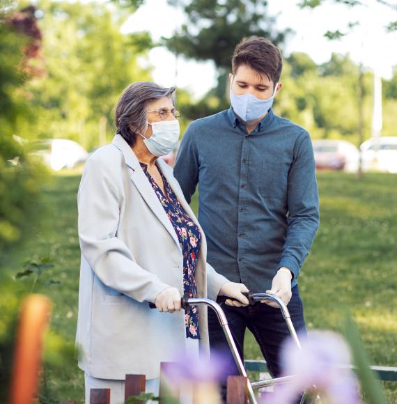 Young man helping elderly care home resident