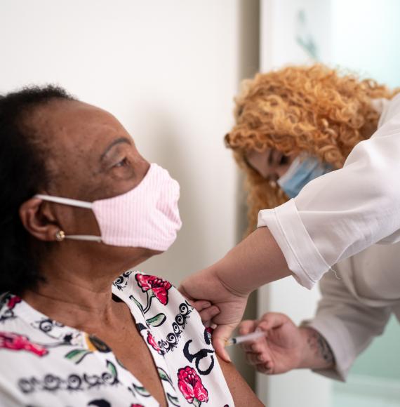 Older woman receiving a vaccine jab