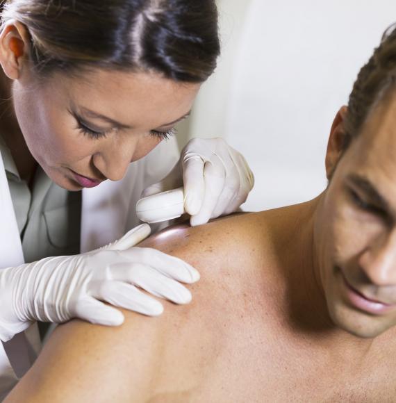 Dermatologist inspecting a patient's skin