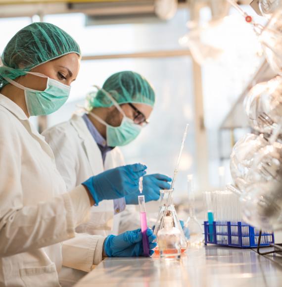 Two lab workers using medical research equipment