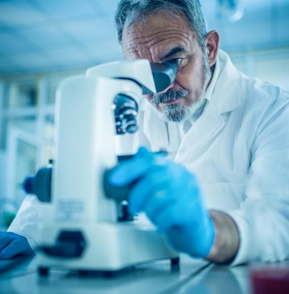 Researcher looking down a microscope