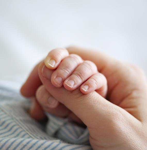 Mother holding a young baby's hand