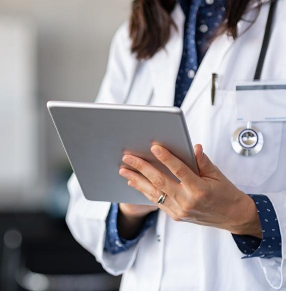 Doctor using a tablet PC to update records