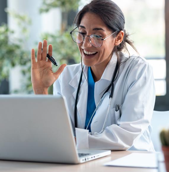 Doctor using a laptop to carry out virtual clinics