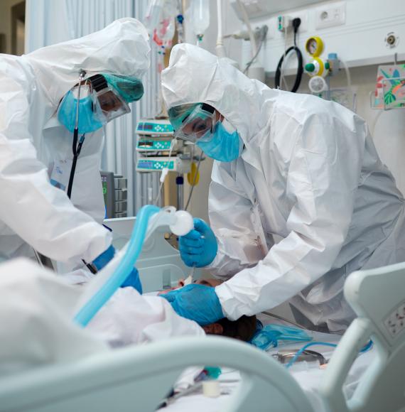 Health workers in PPE intubating a patient