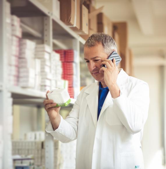 Pharmacist sorting a medical drug from a shelf