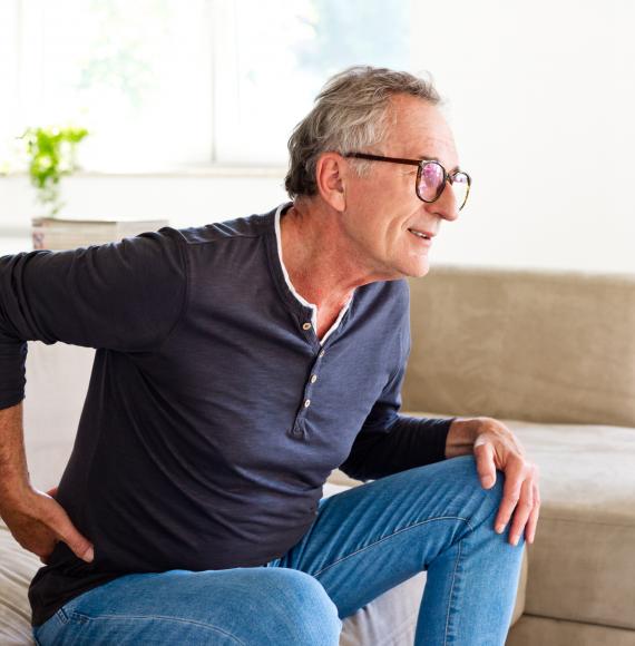 Older man holding his back due to pain