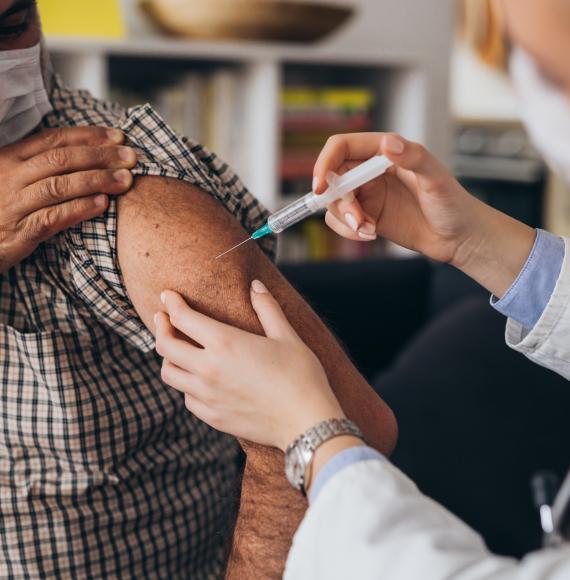 Elderly person receiving a vaccine jab