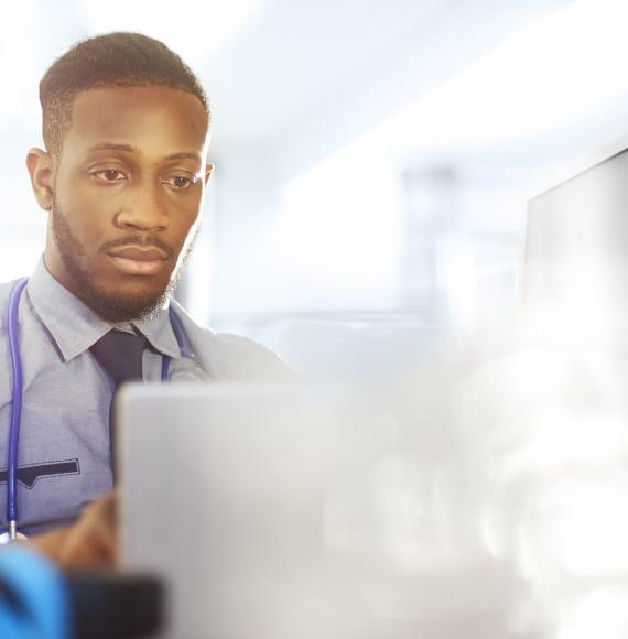 Young doctor checking on a laptop computer