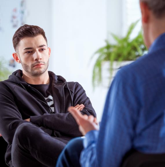 Young withdrawn man talking to a professional