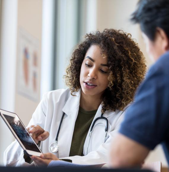 Doctor using a tablet PC to explain heart monitor results