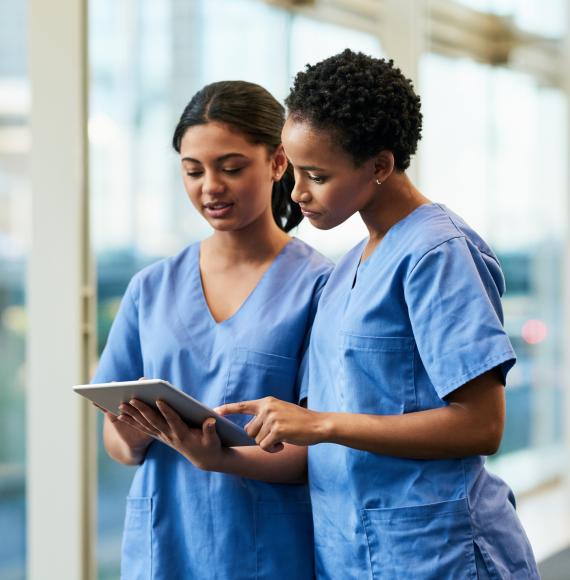 Nurses in conversation looking at a tablet PC