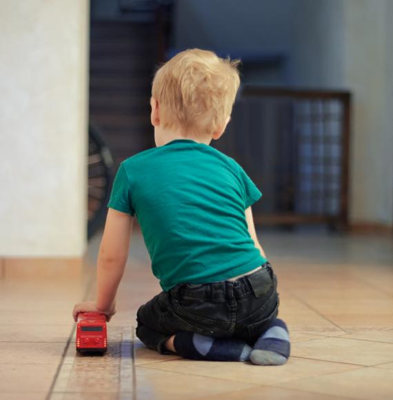 child playing with red bus toy 