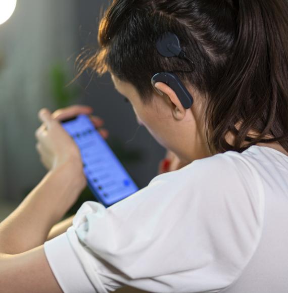 woman with cochlear implant using mobile phone 