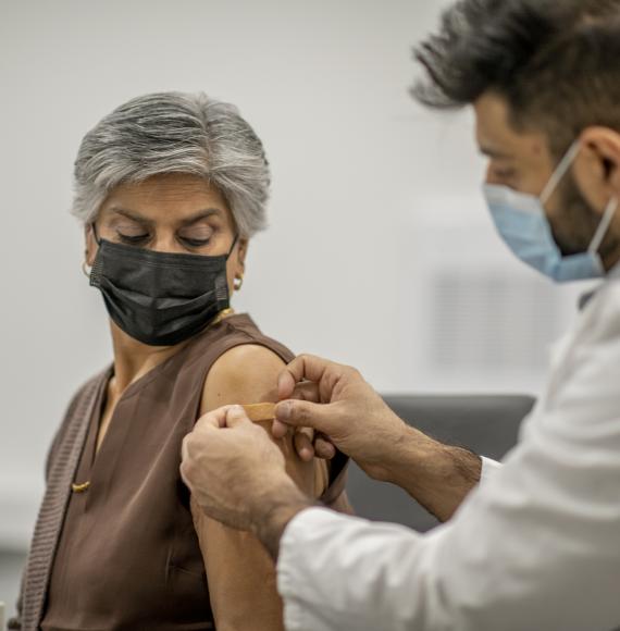 Elderly woman receiving a vaccine jab