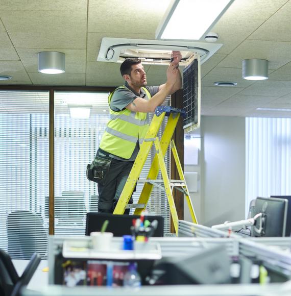 man on ladder changing lightbulb