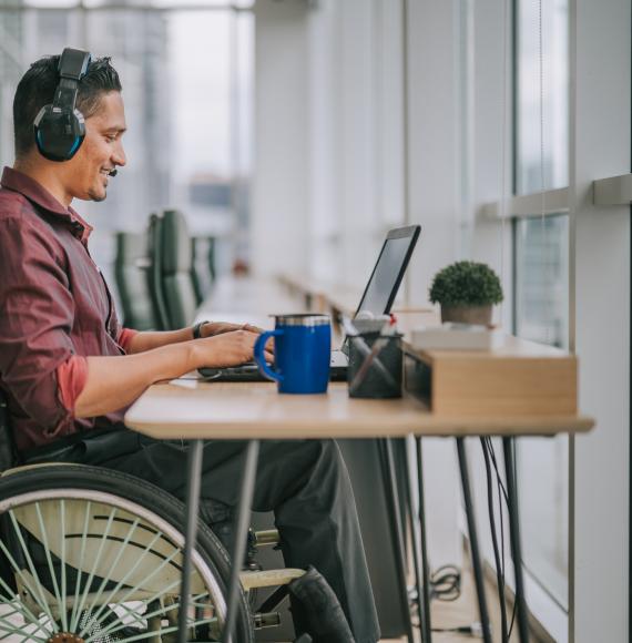 Employee in a wheelchair using a computer at his desk