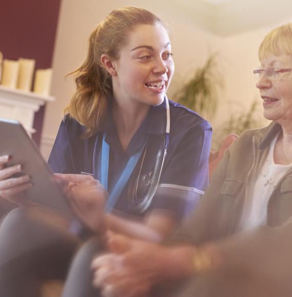 dementia patient using tablet with nurse