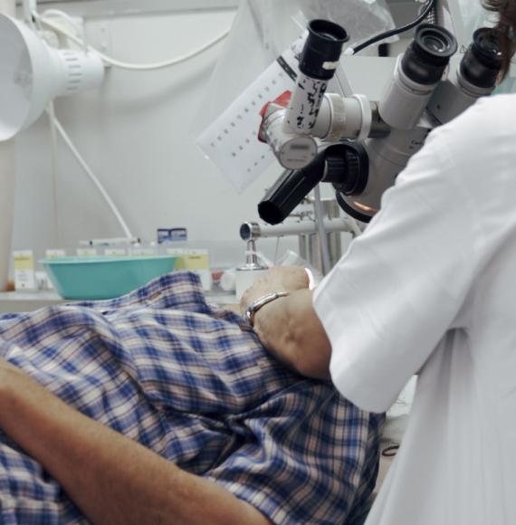 Doctor looking at patient through microscope
