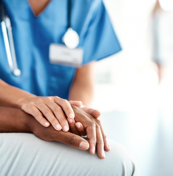 Nurses comforting patient with their hand