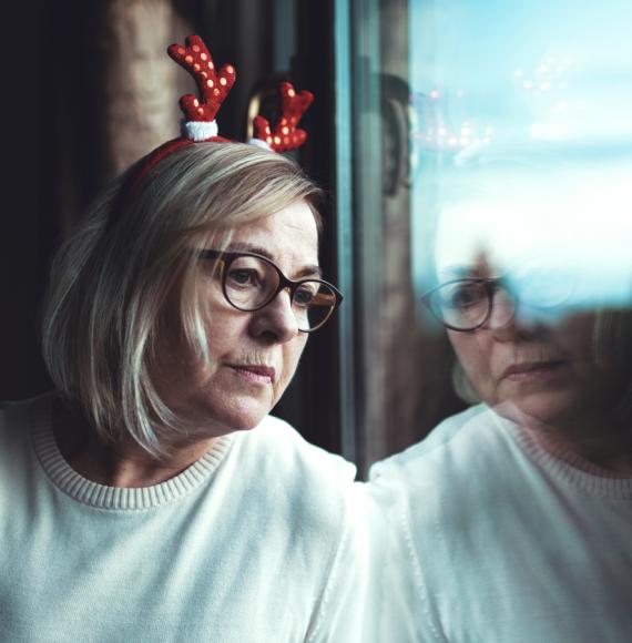 A lonely woman looking out of a window