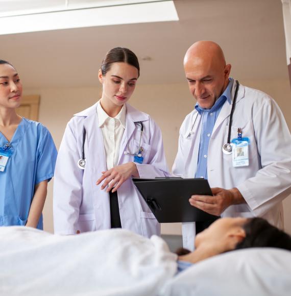 One male and two female doctors with patient