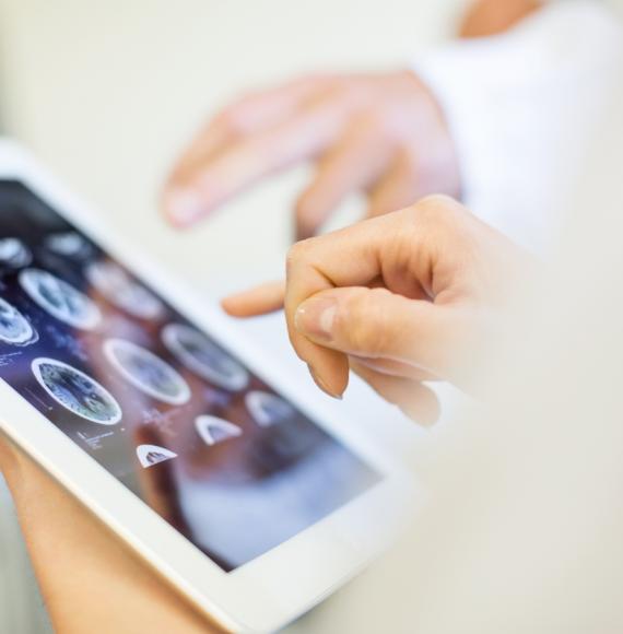 Medical team analysing MRI scans on digital tablet