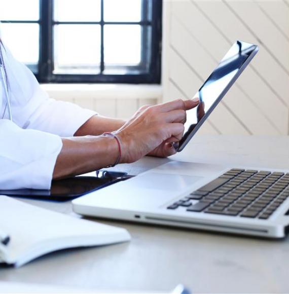 Person using laptop and digital tablet