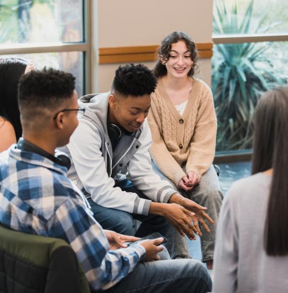 Group of young people sat in a circle talking