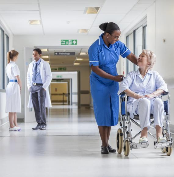 Elderly female patient in wheelchair with nurse