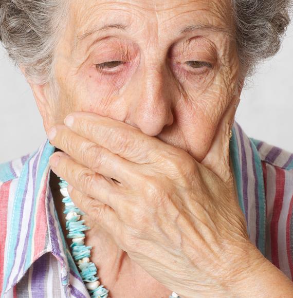 Senior woman with a hand over her mouth