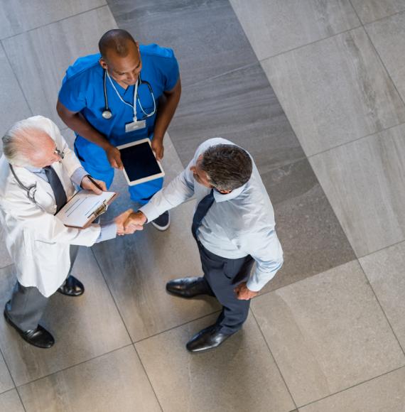 Overhead view of health professionals in agreement and shaking hands