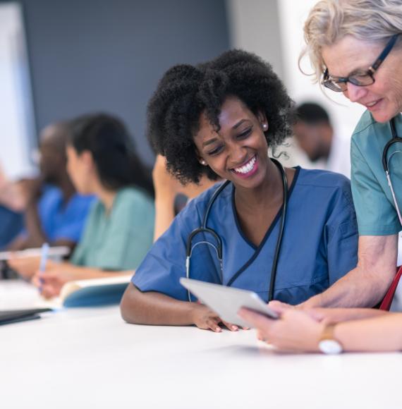 Senior female lecturer assists medical students during class